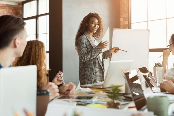 Cheerful businesswoman giving presentation to group